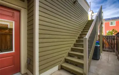 a staircase next to a house with a red door at Old Town North Jewel! Near Breweries and River! in Fort Collins