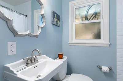 a bathroom with a sink and a toilet and a window at Fun, Family-Friendly Old Town Home with Hot Tub! in Fort Collins