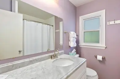 a bathroom with a sink and a mirror and a toilet at Fun, Family-Friendly Old Town Home with Hot Tub! in Fort Collins