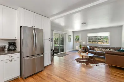 a kitchen and living room with a stainless steel refrigerator at Fun, Family-Friendly Old Town Home with Hot Tub! in Fort Collins