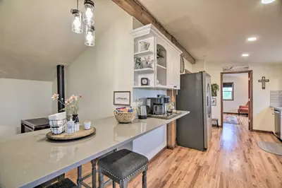 a kitchen with a counter and a refrigerator at Lovely Barn Loft with Mountain Views on Horse Estate in Fort Collins