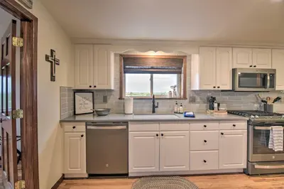 a kitchen with white cabinets and a window at Lovely Barn Loft with Mountain Views on Horse Estate in Fort Collins