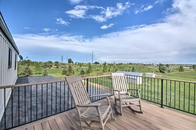 two chairs on a deck with a view of the water at Lovely Barn Loft with Mountain Views on Horse Estate in Fort Collins