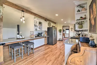 an open kitchen and living room with wooden floors at Lovely Barn Loft with Mountain Views on Horse Estate in Fort Collins