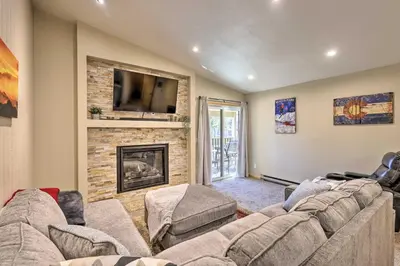a living room with a couch and a fireplace at Cozy Winter Park Condo, Walk to Ski Shuttle! in Winter Park