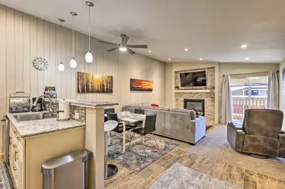 a kitchen and living room with a couch and a table at Cozy Winter Park Condo, Walk to Ski Shuttle! in Winter Park