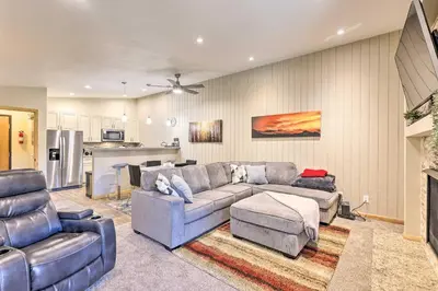 a living room with a couch and a kitchen at Cozy Winter Park Condo, Walk to Ski Shuttle! in Winter Park