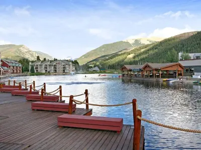 a dock with red benches on a lake with mountains at 1538 Lakeshore condo in Dillon