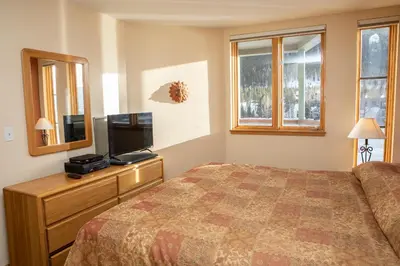 a bedroom with a bed and a flat screen tv at 1538 Lakeshore condo in Dillon