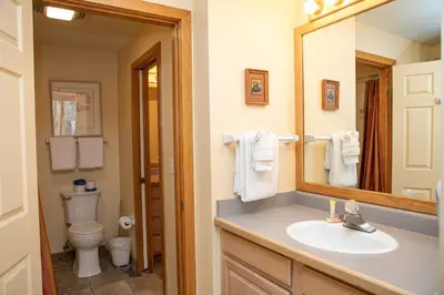a bathroom with a sink and a toilet and a mirror at 1538 Lakeshore condo in Dillon