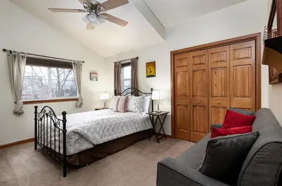 a bedroom with a bed and a couch and a ceiling fan at Sungate Condo: Nice Frisco Location in Frisco