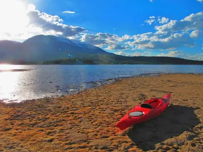 a red kayak sitting on the shore of a lake at Sungate Condo: Nice Frisco Location in Frisco