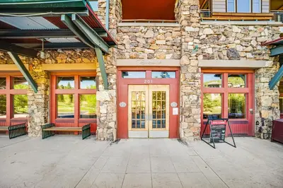 a brick building with a red door and windows at Zephyr Mountain Ski-In Ski-Out Condo in Winter Park