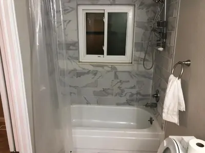 a bathroom with a tub and a window and a toilet at MileHi Vacation Home Pet Friendly in Aurora