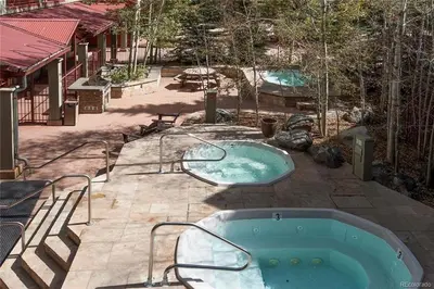 two hot tubs in a yard with a patio at 8282 Silver Mill condo in Keystone