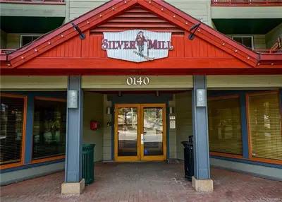 a building with a red roof with a sign on it at 8282 Silver Mill condo in Keystone