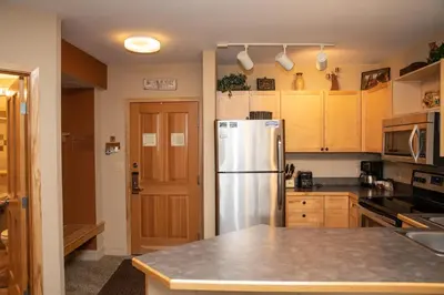 a kitchen with a stainless steel refrigerator and wooden cabinets at 8282 Silver Mill condo in Keystone