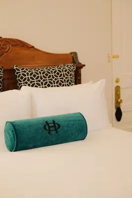 a green towel laying on top of a bed at The Oxford Hotel in Denver