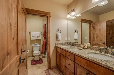 a bathroom with a toilet and a double sink at The Sanctuary Getaway - 192 home in Keystone