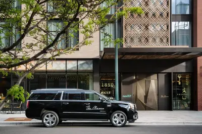 a black limo parked in front of a building at The Maven Hotel at Dairy Block in Denver