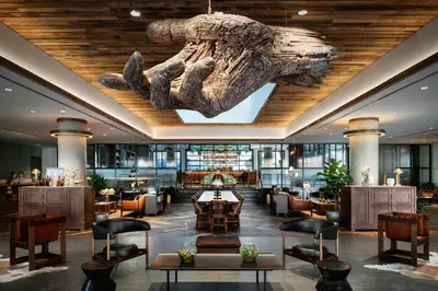 a hotel lobby with a dinosaur fossil hanging from the ceiling at The Maven Hotel at Dairy Block in Denver