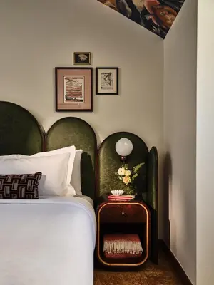 a bedroom with a bed with a green headboard at The Crawford Hotel in Denver