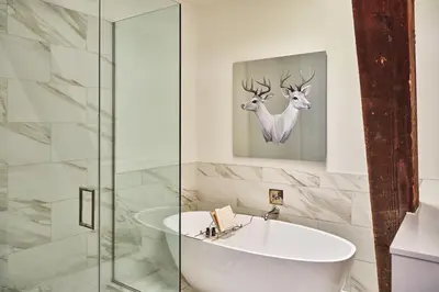a bathroom with a tub and a glass shower at The Crawford Hotel in Denver