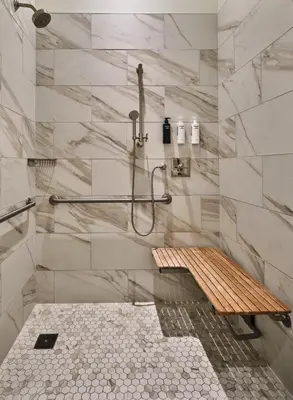 a shower with a bench in a bathroom at The Crawford Hotel in Denver