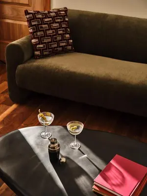 a table with two glasses on top of it with a couch at The Crawford Hotel in Denver