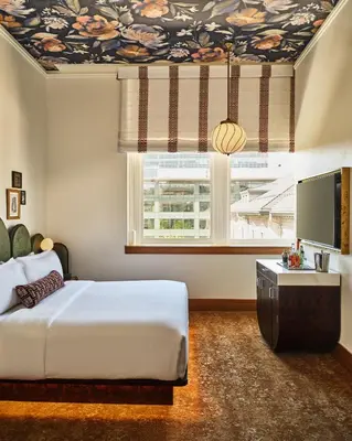 a bedroom with a bed and a large window at The Crawford Hotel in Denver