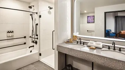 a bathroom with two sinks and a tub and a mirror at The Rally Hotel at McGregor Square in Denver