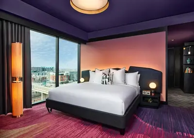 a bedroom with a large bed and a large window at The Rally Hotel at McGregor Square in Denver