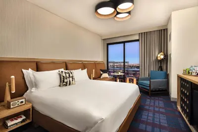 a hotel room with a large bed and a chair at The Rally Hotel at McGregor Square in Denver