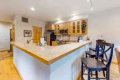 a kitchen with a large counter and two chairs at Family - Friendly 3 Bedroom In River Run Village With Mountain View in Keystone