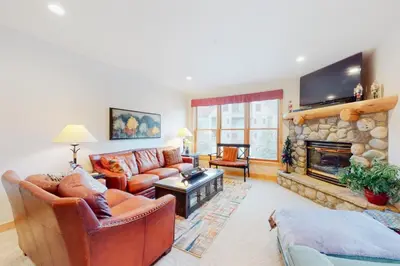 a living room with a couch and a fireplace at Family - Friendly 3 Bedroom In River Run Village With Mountain View in Keystone