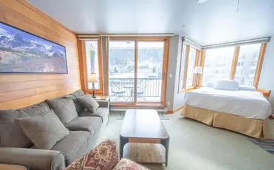 a living room with a couch and a bed at Lakeside 1476 by SummitCove Lodging in Keystone
