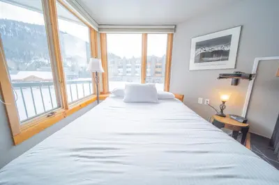 a large bed in a room with a large window at Lakeside 1476 by SummitCove Lodging in Keystone