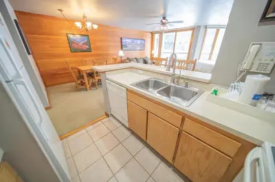 a kitchen with a sink and a dining room at Lakeside 1476 by SummitCove Lodging in Keystone