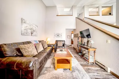 a living room with a leather couch and a table at Granby Condo with Views in Granby