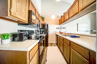 a kitchen with wooden cabinets and a stove top oven at Granby Condo with Views in Granby