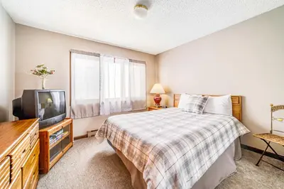 a bedroom with a bed and a television at Granby Condo with Views in Granby