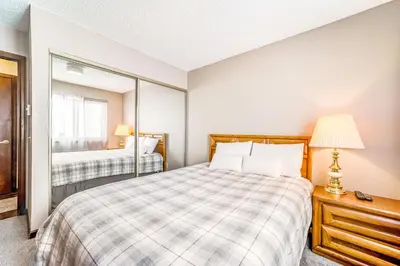 a bedroom with a bed and a mirror at Granby Condo with Views in Granby