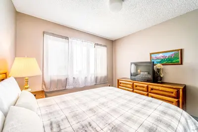 a bedroom with a bed and a tv at Granby Condo with Views in Granby