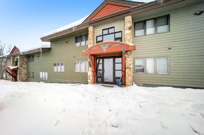 a house with snow in front of it at Granby Condo with Views in Granby