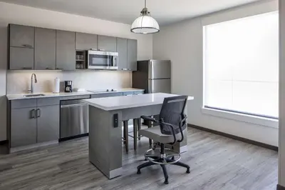 a kitchen with a desk and a chair in a room at Hyatt House Denver Aurora Anschutz Medical Campus in Aurora