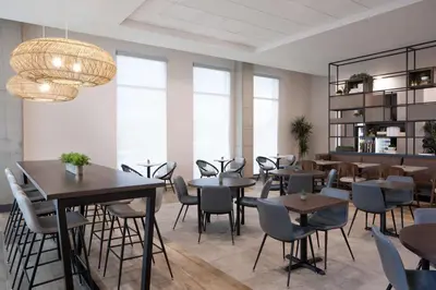 a restaurant with tables and chairs and a chandelier at Hyatt House Denver Aurora Anschutz Medical Campus in Aurora