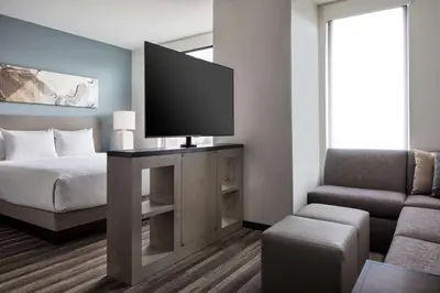a bedroom with a bed and a tv and a chair at Hyatt House Denver Aurora Anschutz Medical Campus in Aurora