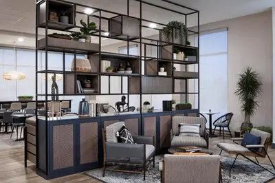 a lobby with chairs and tables and a shelf with plants at Hyatt House Denver Aurora Anschutz Medical Campus in Aurora