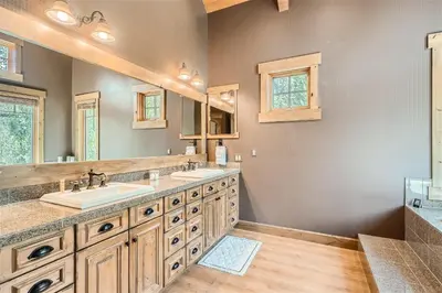 a bathroom with two sinks and a large mirror at Keystone Gulch Estate 1688 estate in Keystone