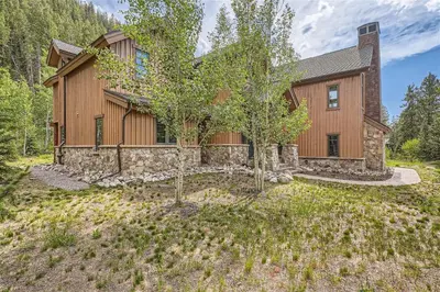 a home in the woods with a stone wall at Keystone Gulch Estate 1688 estate in Keystone